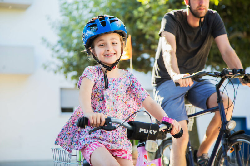 Ein kleines Mädchen fährt glücklich auf dem Fahrrad.