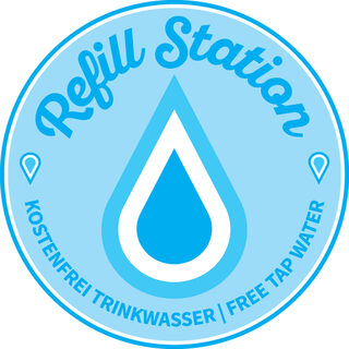 Das Logo von Refill ist ein weißer Wassertropfen, welcher mit weiß und hellblau umrandet ist. In geschwungener Schrift seht oben Refill Station.